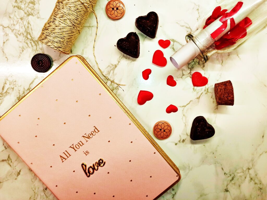 Diary and decorative buttons, and chocolate candies in heart shape 