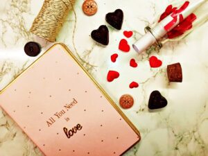 Diary and decorative buttons, and chocolate candies in heart shape 